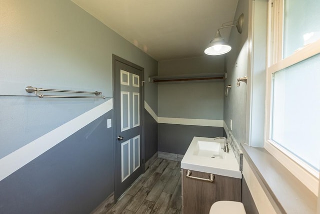 bathroom with baseboards, wood finished floors, and vanity