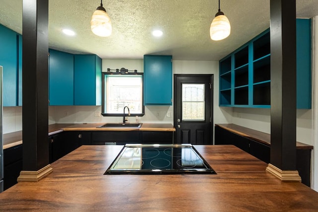 kitchen featuring a sink, a textured ceiling, wooden counters, and black electric stovetop