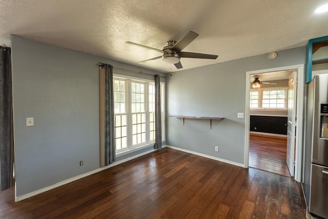 unfurnished room featuring a textured ceiling, baseboards, a ceiling fan, and dark wood-style floors