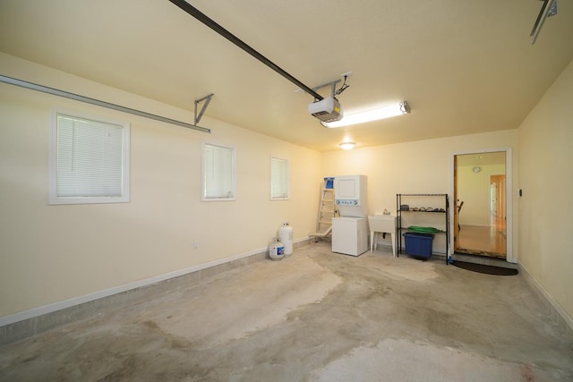 garage featuring a garage door opener, washer / clothes dryer, baseboards, and a sink