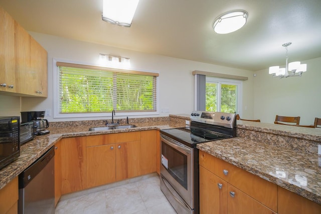 kitchen with appliances with stainless steel finishes, a sink, a chandelier, stone countertops, and pendant lighting