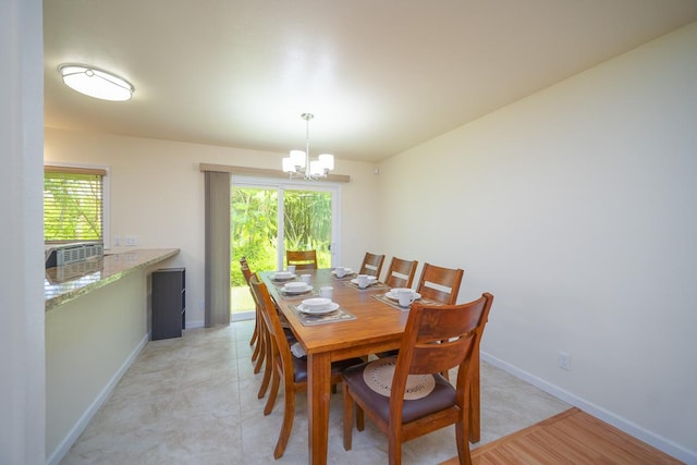 dining room featuring a chandelier, plenty of natural light, and baseboards