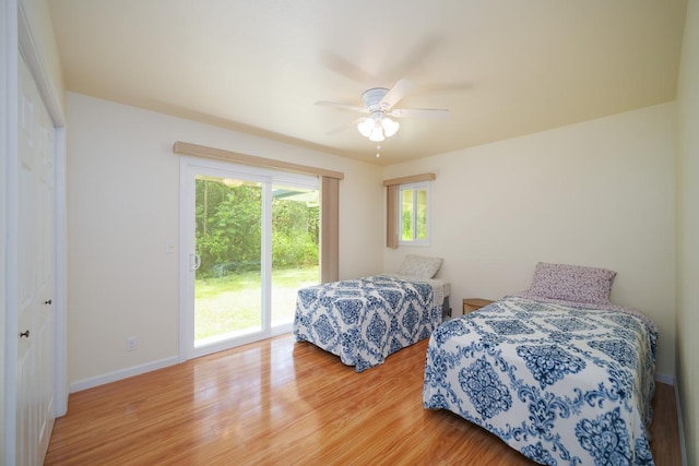 bedroom with wood finished floors, access to exterior, baseboards, and a ceiling fan