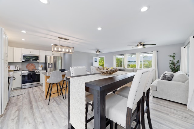 dining room with light wood-style flooring, a ceiling fan, and recessed lighting