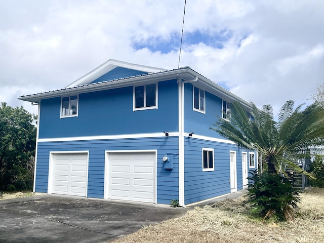 view of side of property featuring a garage and driveway
