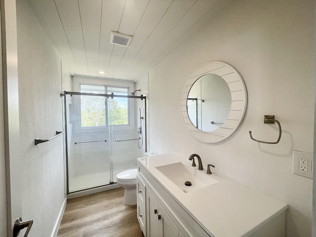 bathroom featuring visible vents, a shower stall, wood finished floors, vanity, and toilet