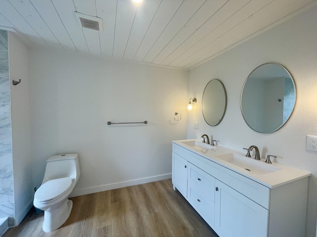 bathroom with wood ceiling, visible vents, a sink, and wood finished floors