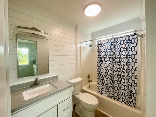 full bathroom with vanity, wood walls, shower / bathtub combination with curtain, and toilet