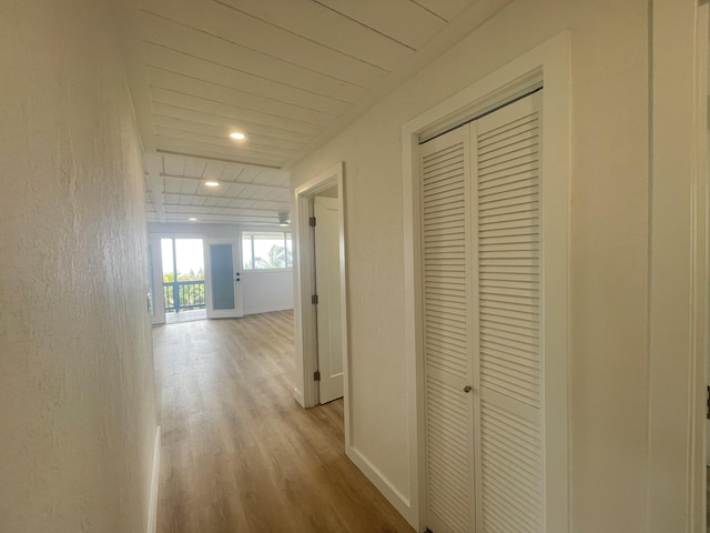 hallway featuring recessed lighting, baseboards, and wood finished floors