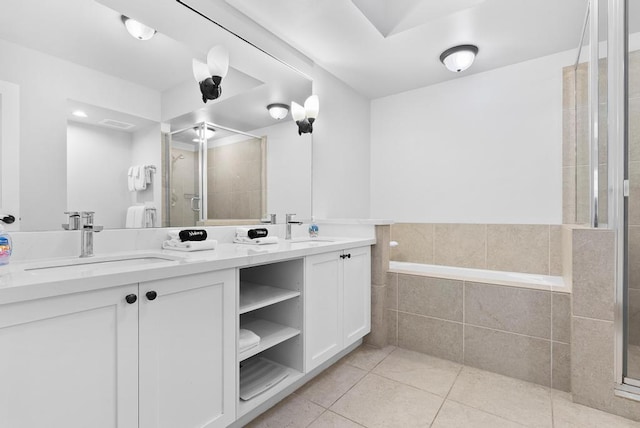 bathroom with a sink, tile patterned flooring, a stall shower, and double vanity