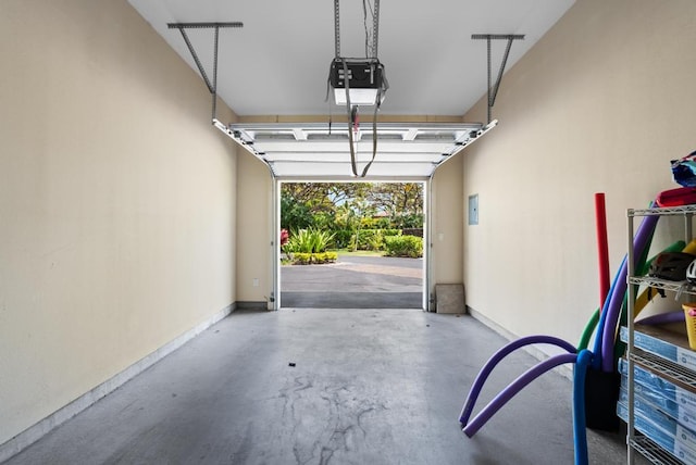 garage with baseboards and a garage door opener