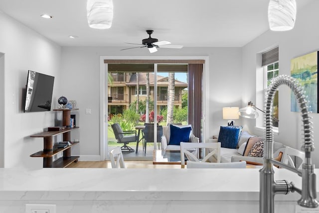 living room featuring a ceiling fan, baseboards, recessed lighting, and wood finished floors