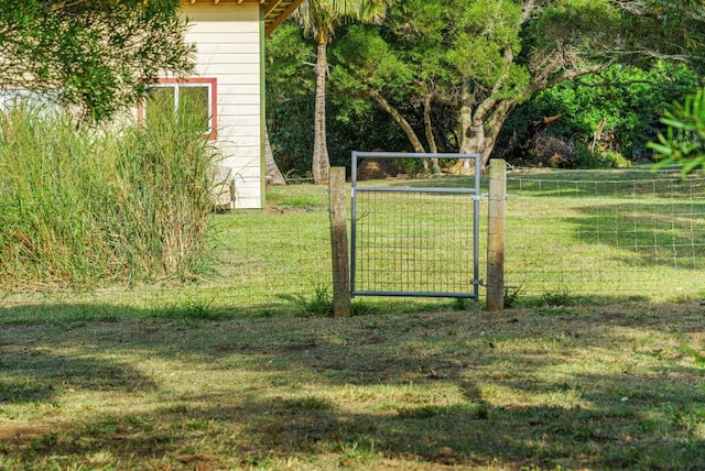 view of gate with a yard and fence