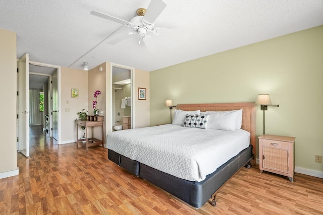 3811 Edward Rd Unit 1206, Princeville, HI 96722 - bedroom featuring wood finished floors, baseboards, a ceiling fan, ensuite bath, and a textured ceiling
