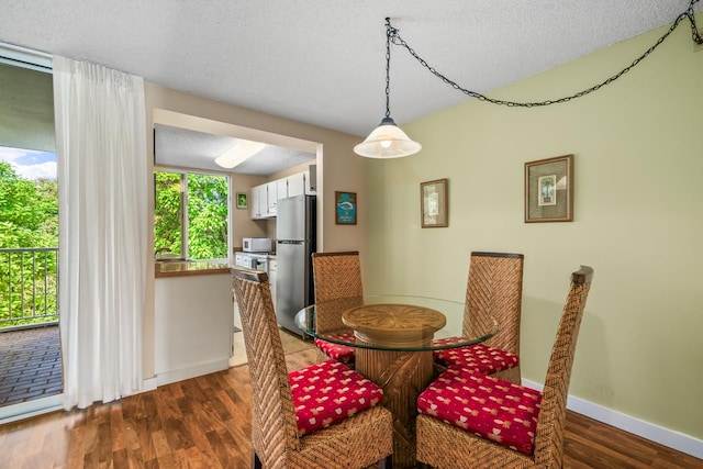 3811 Edward Rd Unit 1206, Princeville, HI 96722 - dining room featuring dark wood finished floors, baseboards, and a textured ceiling
