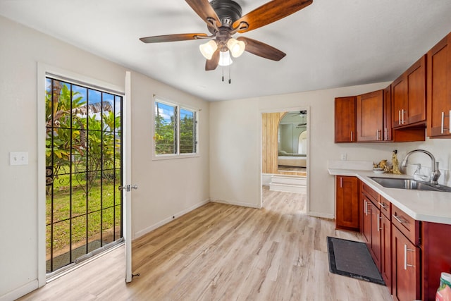 242 Koili Ln, Kapaa, HI 96746 - kitchen featuring a sink, light wood-type flooring, baseboards, ceiling fan, and light countertops