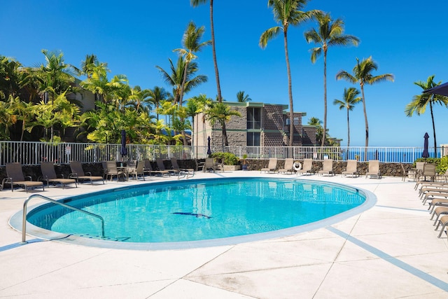 pool with a patio and fence