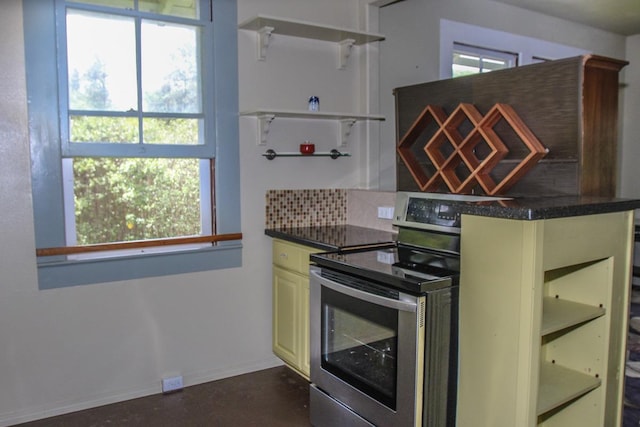 kitchen featuring electric stove, open shelves, dark countertops, cream cabinets, and baseboards