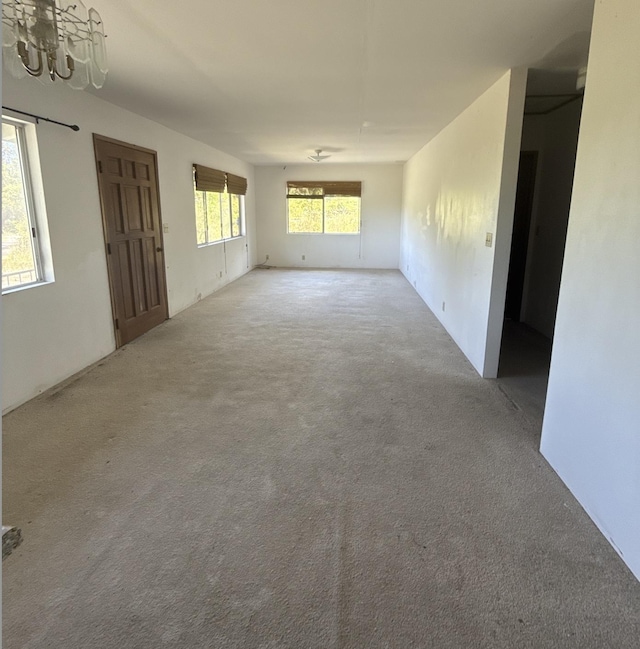 1360 Kaumana Dr, Hilo, HI 96720 - unfurnished living room with carpet floors and an inviting chandelier
