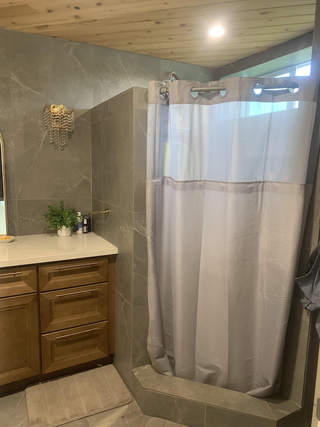 full bathroom with wooden ceiling, tile walls, vanity, and a stall shower