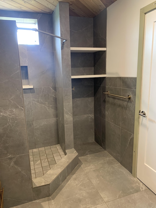 bathroom featuring wooden ceiling, a tile shower, and marble finish floor