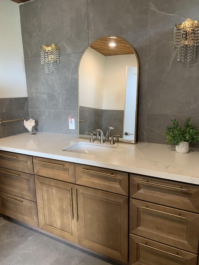 bathroom with tile walls, backsplash, vanity, and marble finish floor
