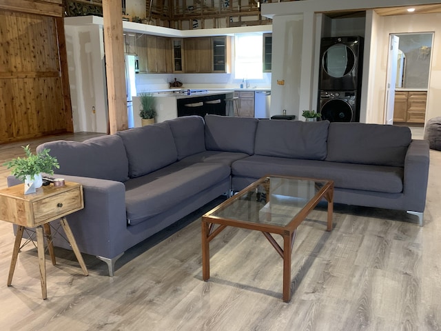 living room featuring light wood-style floors and stacked washer and dryer
