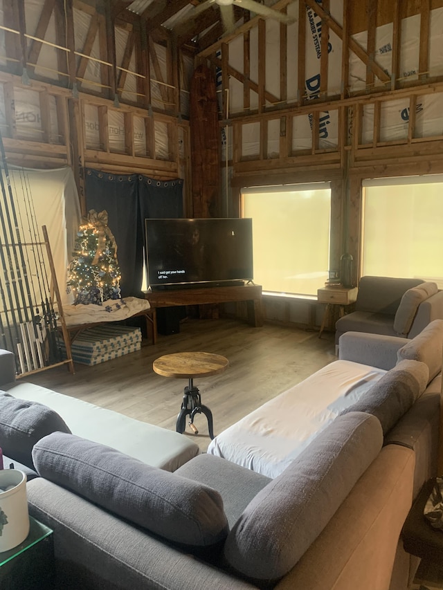 living room with wood finished floors and high vaulted ceiling