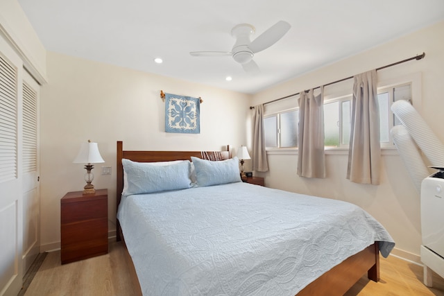 bedroom featuring a closet, wood finished floors, baseboards, and recessed lighting