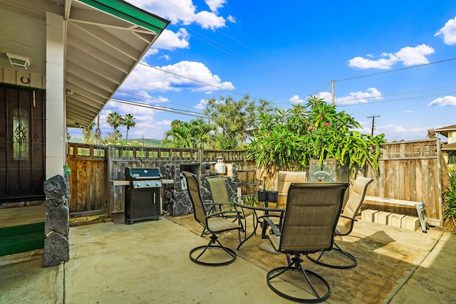 view of patio featuring a fenced backyard, outdoor dining area, and grilling area