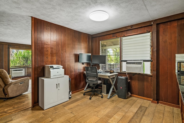 office area with wood walls and a textured ceiling