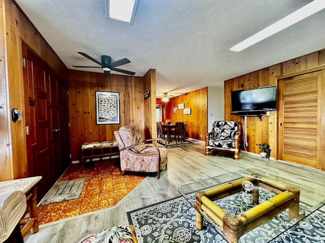 73-1228 Kaiminani Dr, Kailua-Kona, HI 96740 - living area with wood finished floors, wood walls, a textured ceiling, ceiling fan, and baseboards