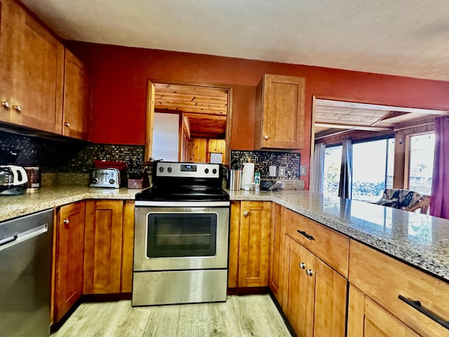 73-1228 Kaiminani Dr, Kailua-Kona, HI 96740 - kitchen with appliances with stainless steel finishes, light wood-style flooring, decorative backsplash, brown cabinets, and light stone counters