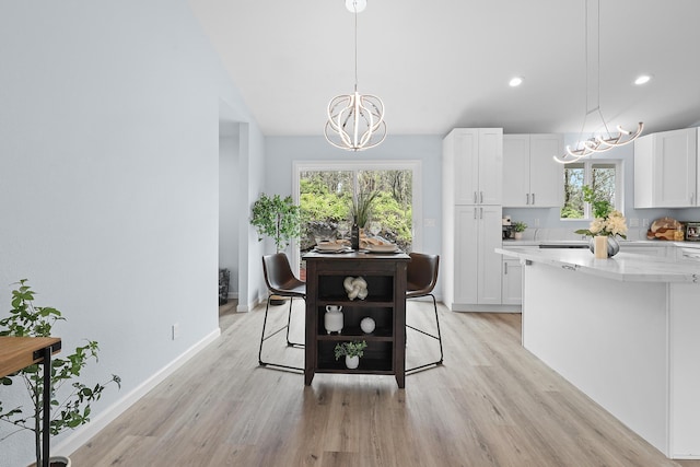 dining area featuring a chandelier, light wood finished floors, healthy amount of natural light, and recessed lighting