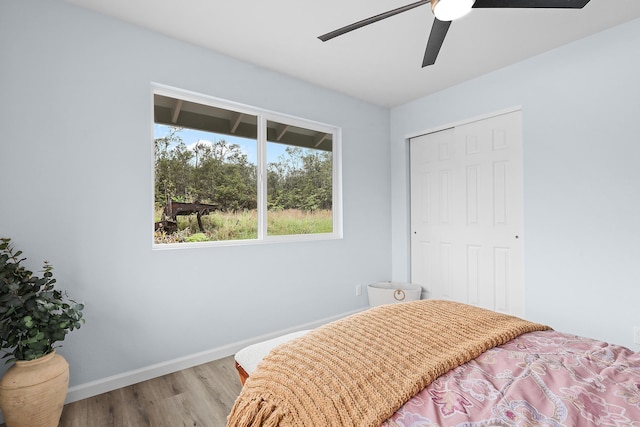 bedroom featuring wood finished floors, baseboards, a closet, and a ceiling fan