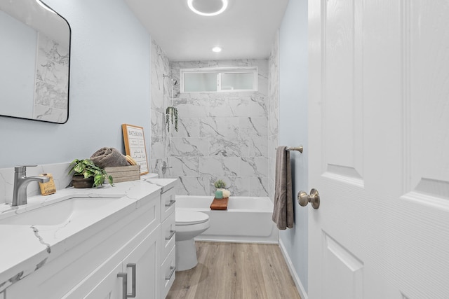 bathroom featuring toilet, wood finished floors, shower / bathtub combination, and vanity