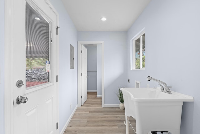 bathroom with wood finished floors, plenty of natural light, baseboards, a freestanding bath, and recessed lighting