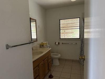 bathroom featuring toilet, tile patterned floors, and vanity