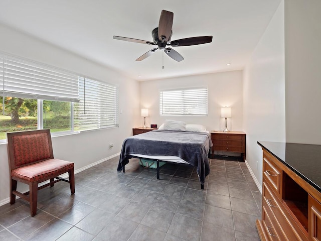 tiled bedroom featuring baseboards, multiple windows, and ceiling fan