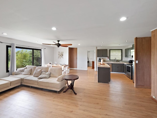 living room with light wood-style floors, baseboards, ceiling fan, and recessed lighting
