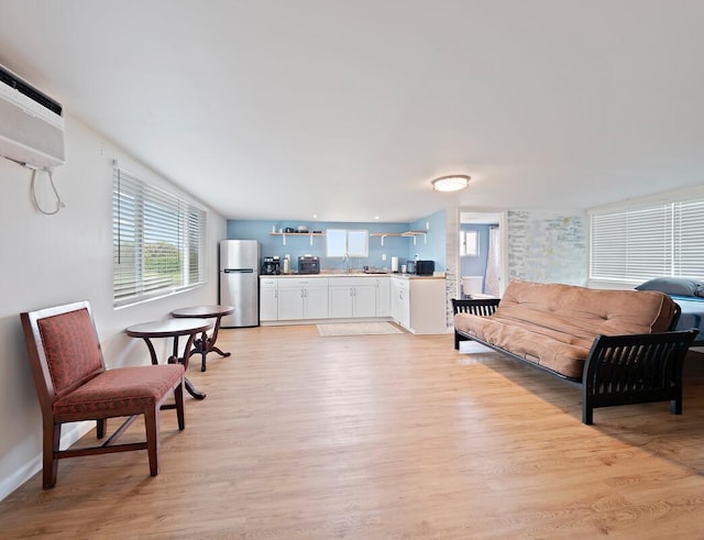 living room featuring plenty of natural light, light wood finished floors, and baseboards