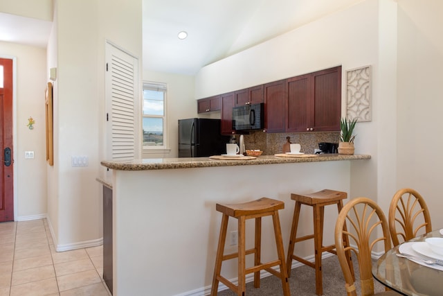 69-200 Pohakulana Pl Unit J33, Waikoloa, HI 96738 - kitchen featuring black appliances, backsplash, a kitchen bar, vaulted ceiling, and a peninsula