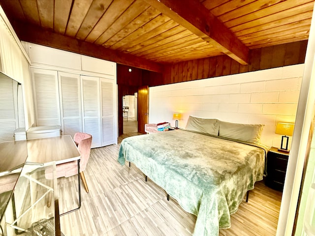 bedroom featuring beamed ceiling, wood walls, a closet, and wooden ceiling