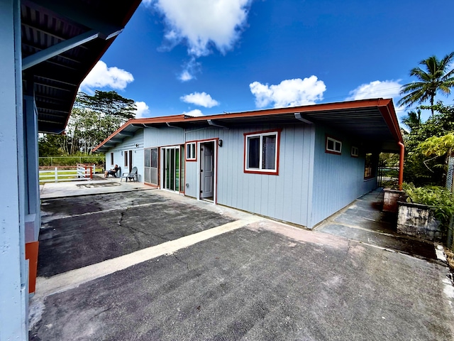view of side of home featuring a patio and fence