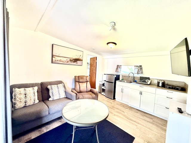 living area with light wood-type flooring and vaulted ceiling