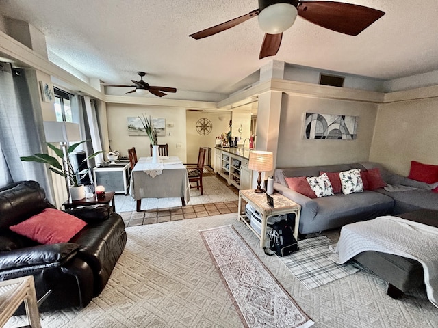 living room with ceiling fan and a textured ceiling