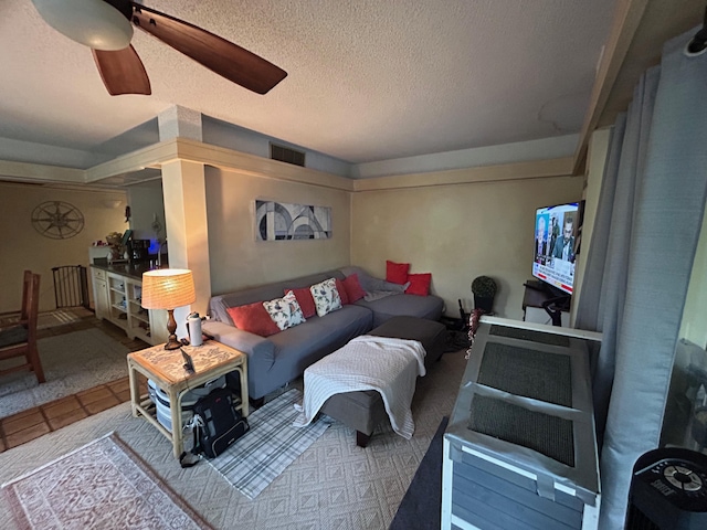 living room with a textured ceiling and a ceiling fan