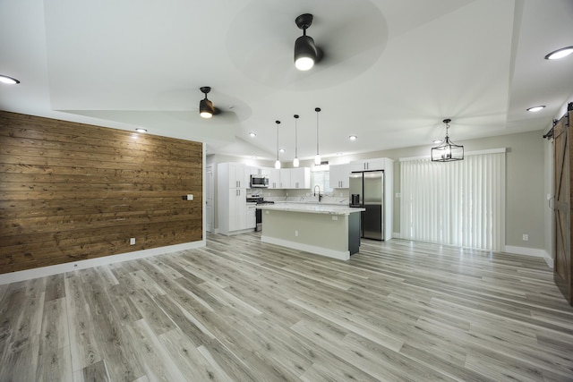 16-2074 Sandalwood Dr, Pahoa, HI 96778 - unfurnished living room with a barn door, a ceiling fan, recessed lighting, light wood-style flooring, and wood walls