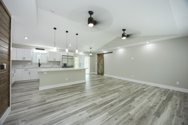 16-2074 Sandalwood Dr, Pahoa, HI 96778 - unfurnished living room with a barn door, ceiling fan, lofted ceiling, light wood finished floors, and a sink