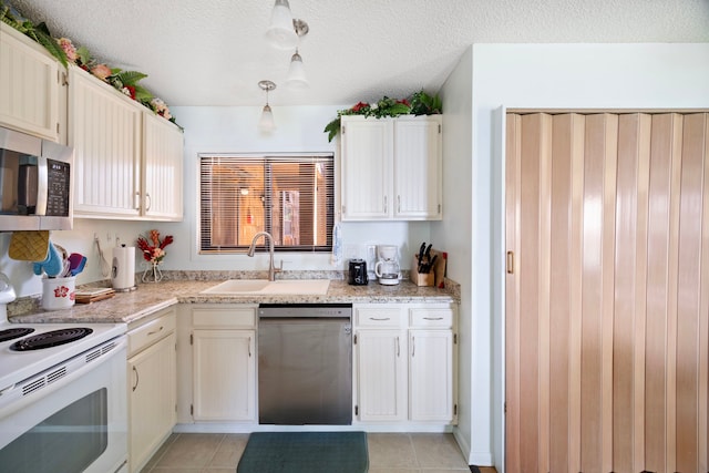 kitchen featuring a sink, stainless steel appliances, light tile patterned flooring, and light stone countertops